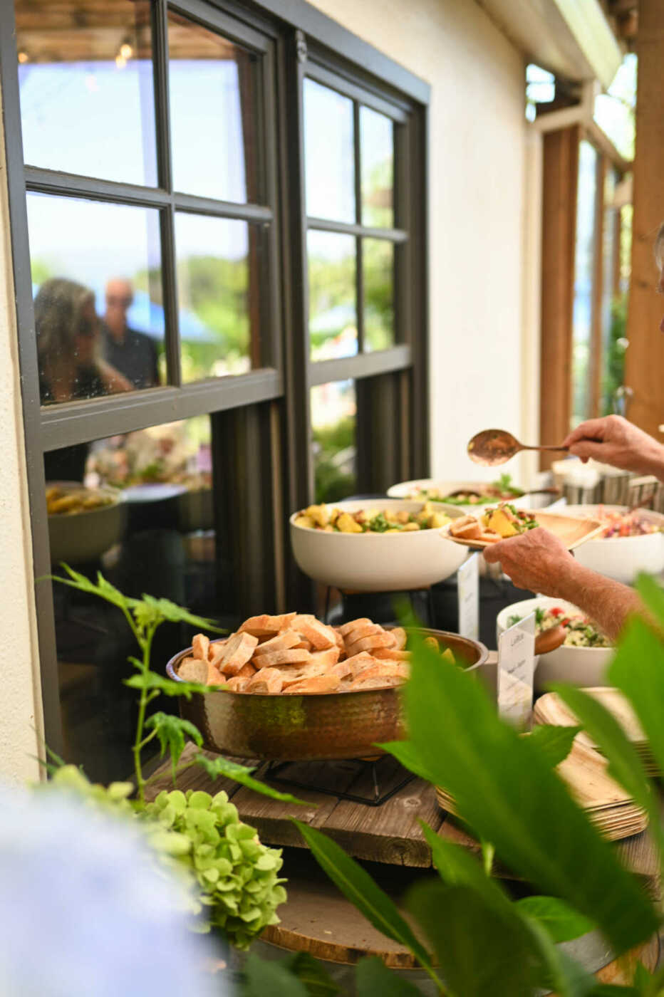 A group of people serving food from a buffet table.