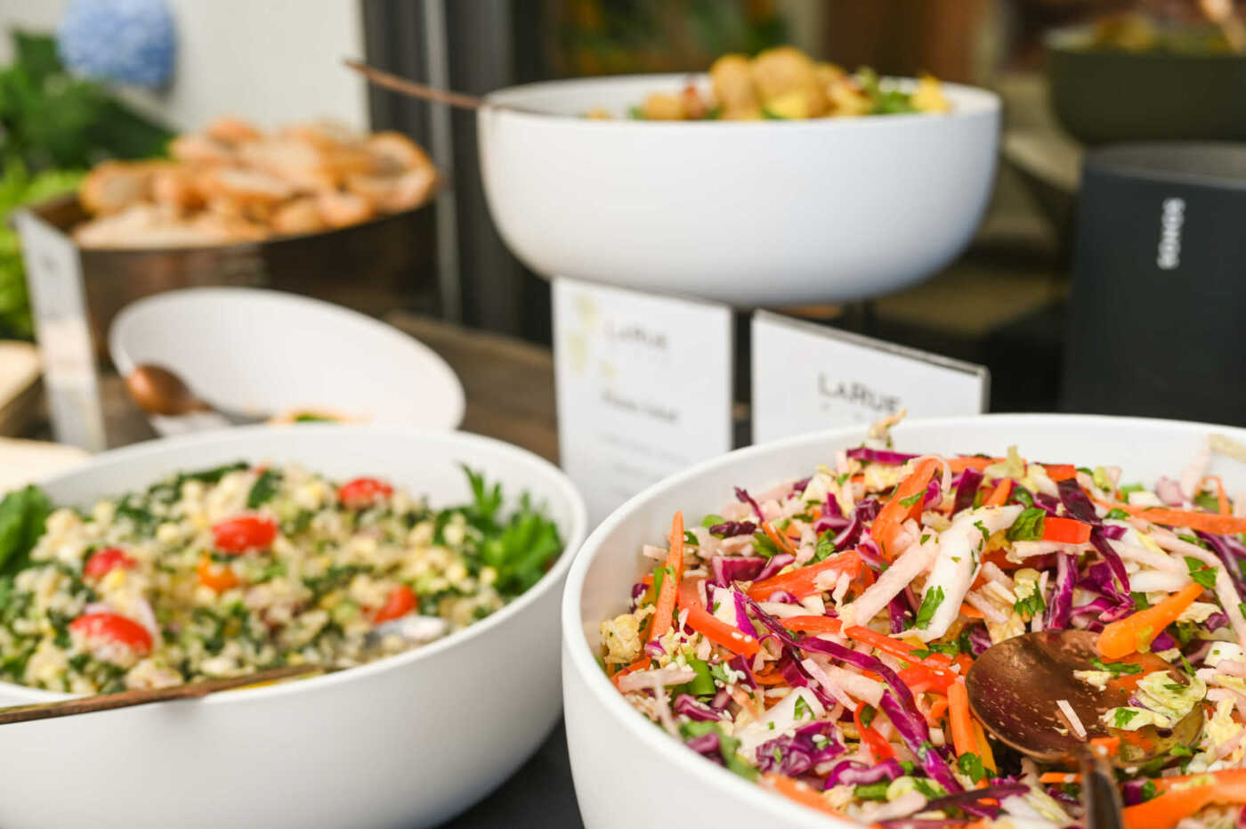 A variety of bowls of salads on a table.