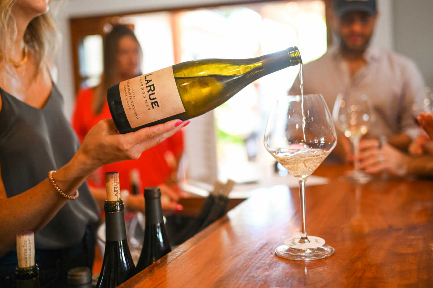 A person pouring a wine into a glass.